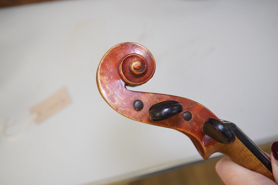 A late 19th century violin, bears fake Stradivarius label, cased, back measures 36cm. Condition - fair